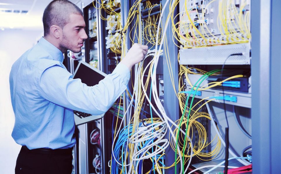 young engeneer business man with thin modern aluminium laptop in network server room